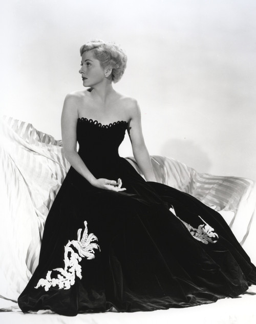 Joan Fontaine sitting on a Couch wearing Black Gown Photo Print - Item # VARCEL689406