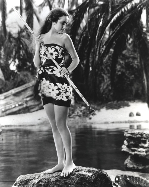 Dorothy Lamour standing next to the water carrying a bamboo stick Photo Print - Item # VARCEL689898