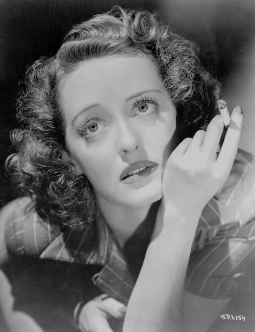 Bette Davis Close Up Portrait Looking Up in Black Suit Dress while Holding a Cigarette Photo Print - Item # VARCEL692937