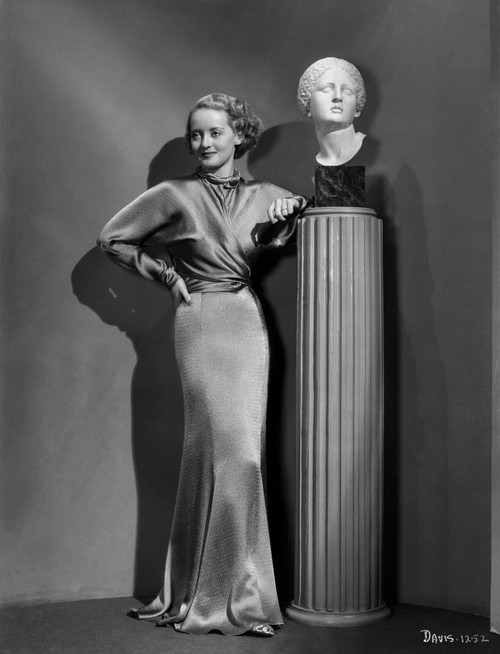 Bette Davis Posed standing Beside on a Roman Column Stand in Long Sleeve Velvet Long Dress Photo Print - Item # VARCEL693030