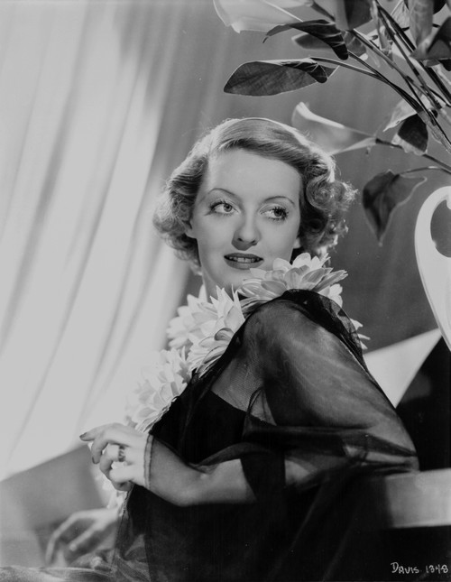 Bette Davis Portrait Lying Back on a Table in Sunflower Garland and Black Linen Lace Long Sleeves Photo Print - Item # VARCEL693441