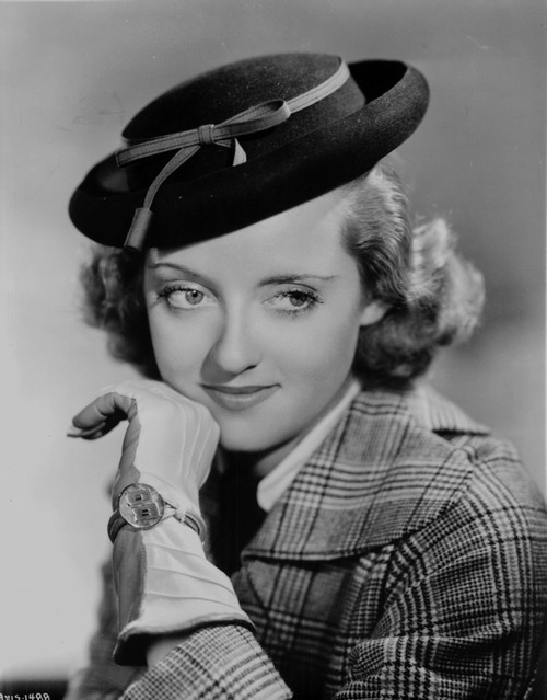Bette Davis Portrait in Flat Top Hat with Chin Leaning on Hand in Checkered Suit and Black Tie Photo Print - Item # VARCEL693456