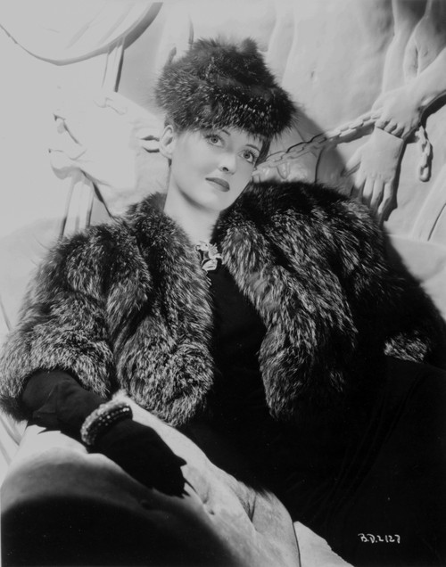 Bette Davis Posed with Hand on the Lap in Black Fur Coat and Black Dress with Black Gloves Photo Print - Item # VARCEL693464