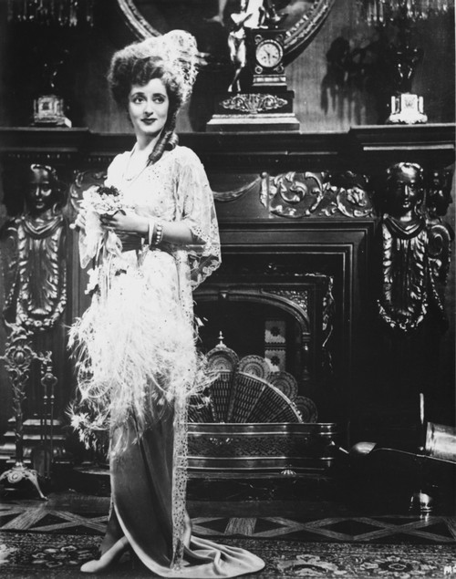 Bette Davis Posed Hands on a White Silk Cloth in White Silk Bonnet and White Pointed Sleeve Silk Dress Photo Print - Item # VARCEL693602