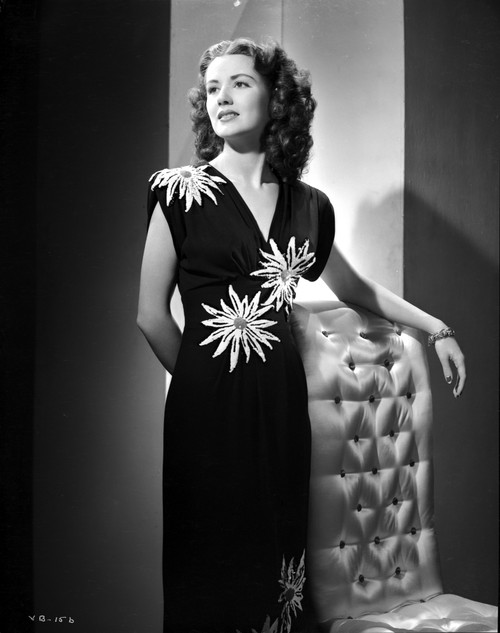 Virginia Belmont on a Printed Dress standing and Leaning on Chair Photo Print - Item # VARCEL694000