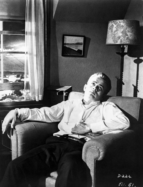 James Dean Seated and Leaning Back on a Couch in White Long Sleeve Collar Shirt and Black Linen Pants Photo Print - Item # VARCEL694053