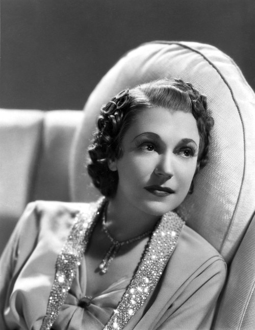 Alice Brady sitting on the Sofa wearing a Necklace Photo Print - Item # VARCEL694672