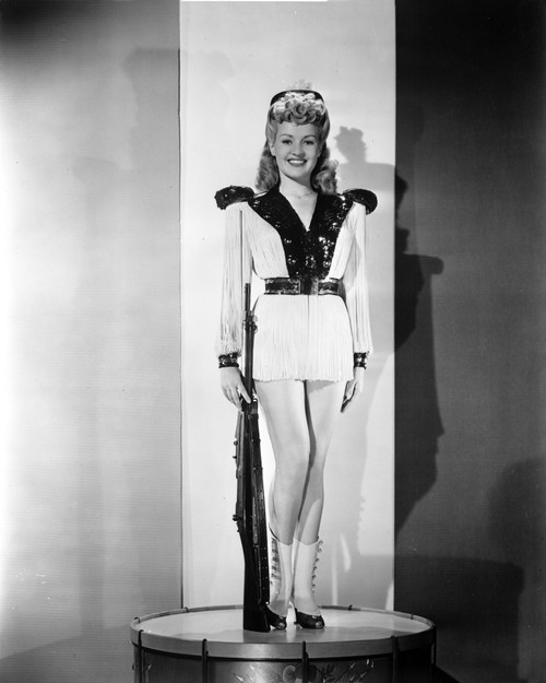 Betty Grable Posed with Hands on the Side in White Long Sleeve Silk V-Neck Shirt with Black Collar and Short Skirt Photo Print - Item # VARCEL695303
