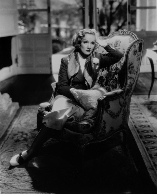 Marlene Dietrich sitting on Couch, wearing Black Dress with Head Leaning on Hand Photo Print - Item # VARCEL695293