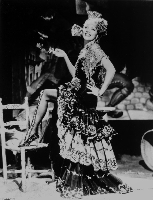 Marlene Dietrich standing One Leg in Floral Gown with One Leg Stepping on Chair Photo Print - Item # VARCEL695432