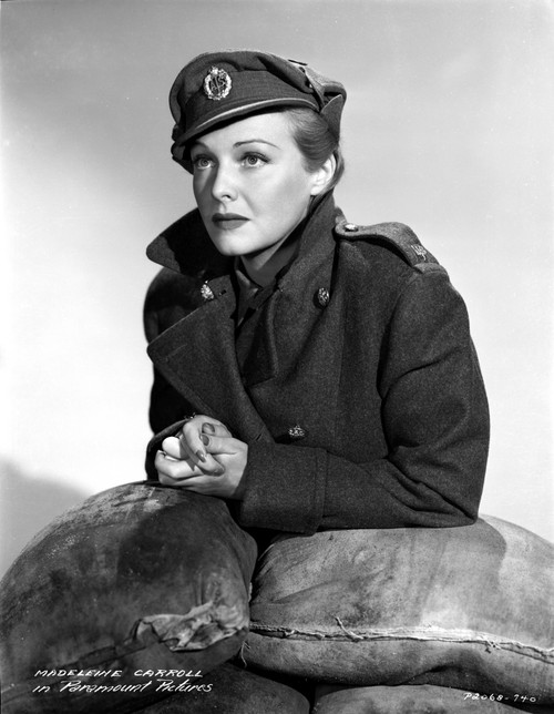 Madeleine Carroll Leaning on Sandbags, wearing Black Suit with Hat Photo Print - Item # VARCEL695550