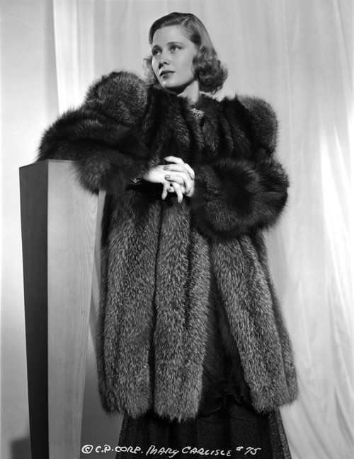Mary Carlisle Leaning on a Wooden Post in Black Furry Jacket Photo Print - Item # VARCEL695708