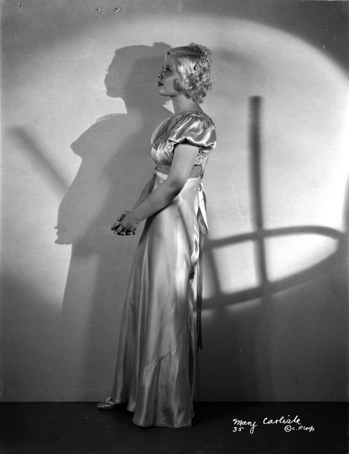 Mary Carlisle standing in White Shiny Dress Photo Print - Item # VARCEL695743