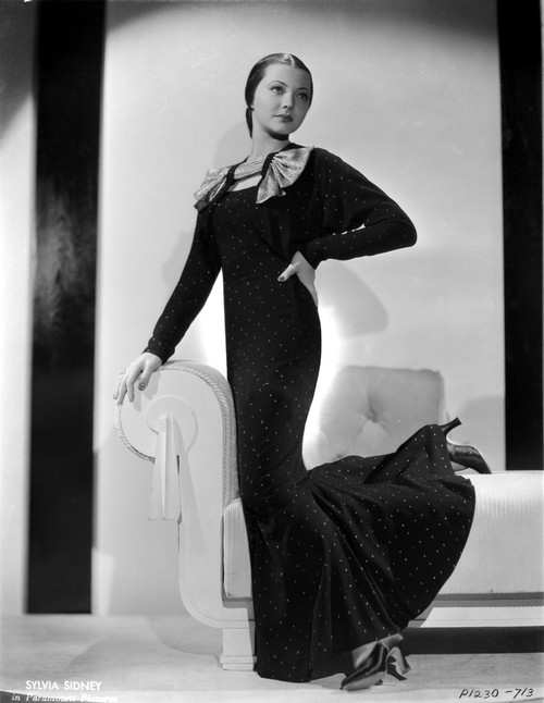 Sylvia Sidney posed on a White Couch in a Black Long Gown Photo Print - Item # VARCEL704564
