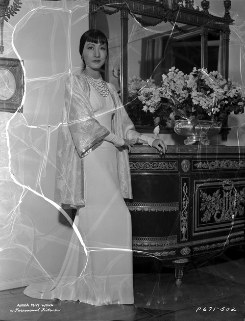 Anna Wong Leaning on a Table, wearing a Long White Dress Photo Print - Item # VARCEL705647