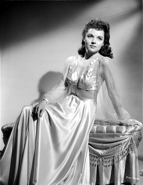 Jane Wyatt Seated on a Couch in White V-Neck Sheer Long Sleeve Silk Dress with Right Hand on the Right Knee Photo Print - Item # VARCEL705804