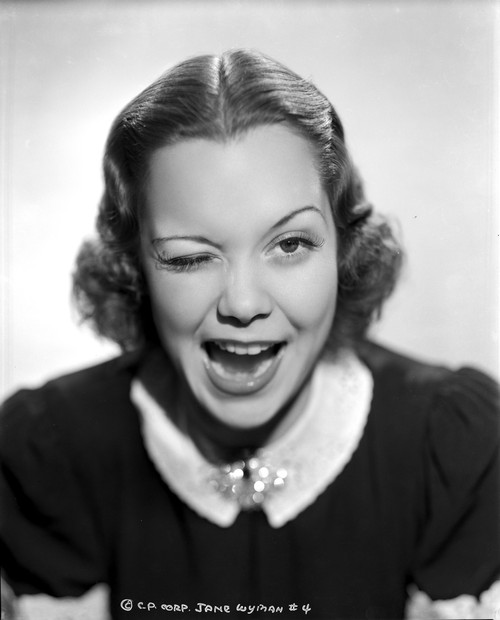 Jane Wyman Portrait in Black Velvet Short Sleeve Dress and White Collar with Right Eye Winked Photo Print - Item # VARCEL705884