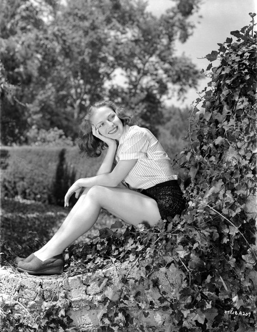 Vera Zorina sitting on vine covered rock, with her head leaned into her head, smiling away from the camera Photo Print - Item # VARCEL705952
