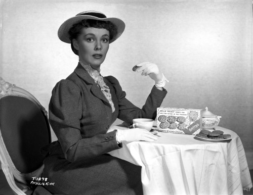 Phyllis Kirk Eating Cookies wearing Black Formal Dress with Hat Photo Print - Item # VARCEL706147