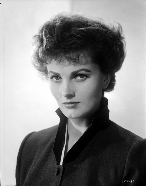 Ursula Theiss staring intently into the camera, wearing a high-neck, buttoned ensemble Photo Print - Item # VARCEL706377