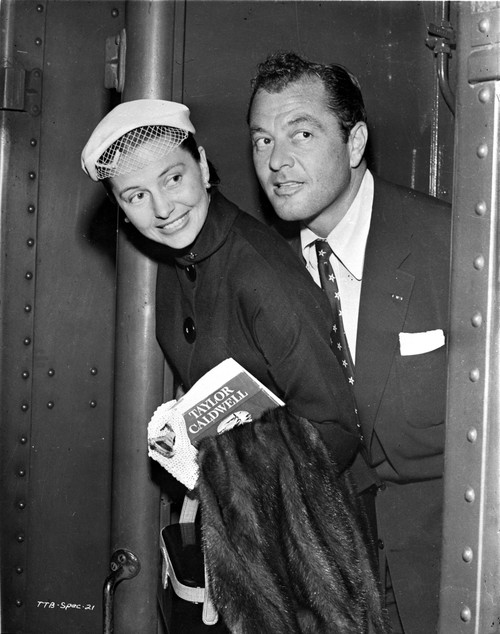 Cyd Charisse smiling and Holding a Book and a Jacket Photo Print - Item # VARCEL706464