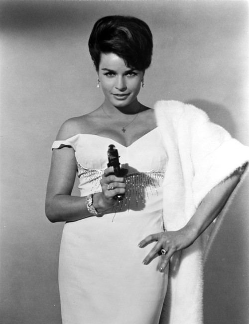 Senta Berger standing in White Dress with Pistol Photo Print - Item # VARCEL707693