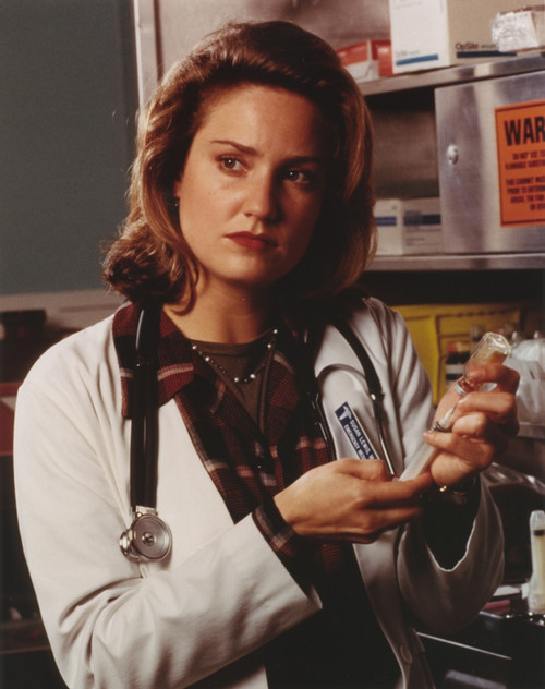 Sherry Stringfield Portrait in Medical Uniform and Brown Collar Shirt with Hands Holding a Syringe Photo Print - Item # VARCEL708101