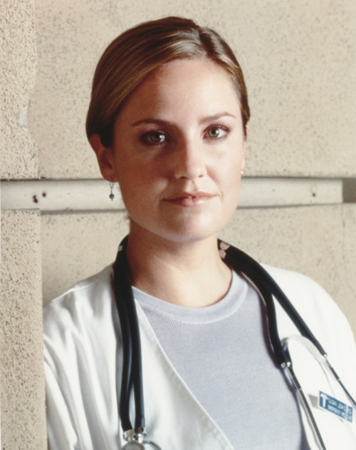 Sherry Stringfield Posed in White Long Sleeve Coat and Grey Round Neck Shirt with Stethoscope Around the Neck Photo Print - Item # VARCEL708105