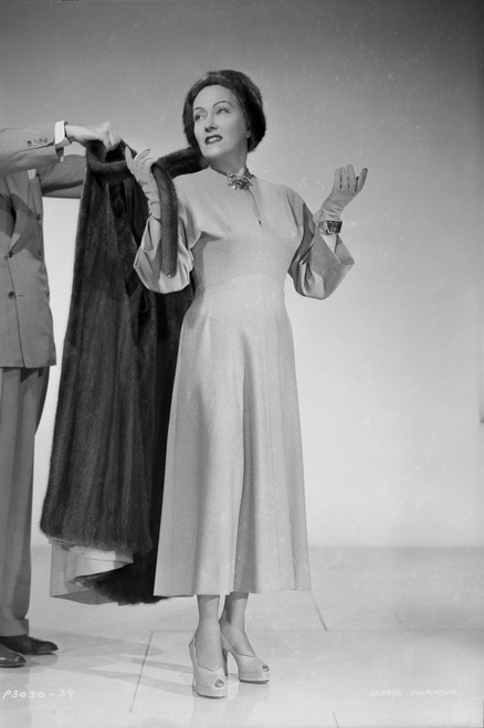 Gloria Swanson Putting Black Coat Photo Print - Item # VARCEL708167
