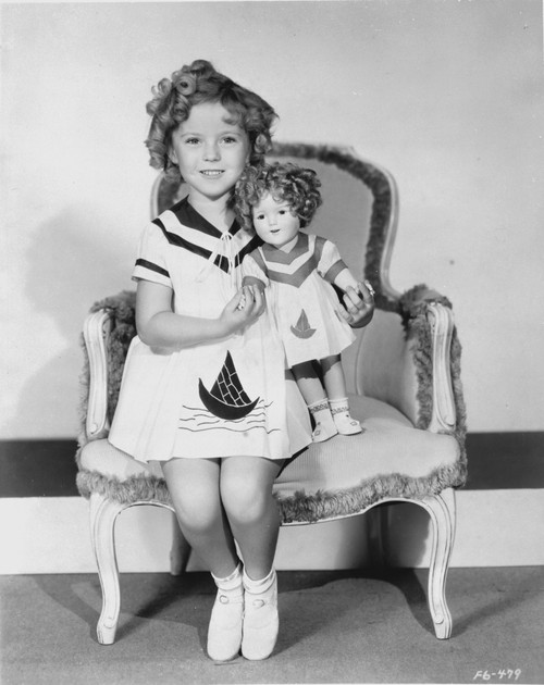 Shirley Temple sitting on Chair with a Doll in White Dress Photo Print - Item # VARCEL708430