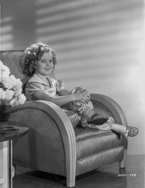 Shirley Temple sitting on the Couch while smiling Photo Print - Item # VARCEL708492