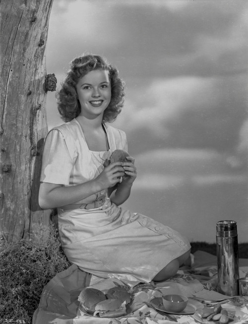 Shirley Temple Kneeling on the Ground and Leaning on a Tree Photo Print - Item # VARCEL708475