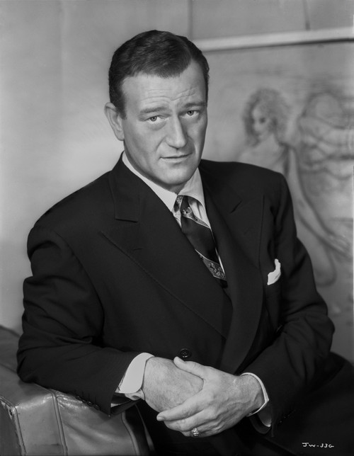 John Wayne wearing a Black Suit while Leaning on a Bag Photo Print - Item # VARCEL709221