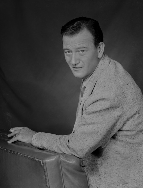 John Wayne Leaning on a Foam, wearing a Suit Photo Print - Item # VARCEL709235