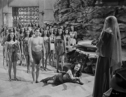 Johnny Weissmuller standing in Front of the Leader of the Amazons in a Movie Scene Photo Print - Item # VARCEL709375