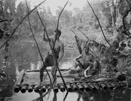 Johnny Weissmuller Riding a Raft with His Friends in a Classic Movie Scene Photo Print - Item # VARCEL709417