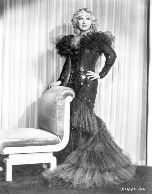 Mae West standing in Black Long Gown with One Hand on Hips Photo Print - Item # VARCEL709656