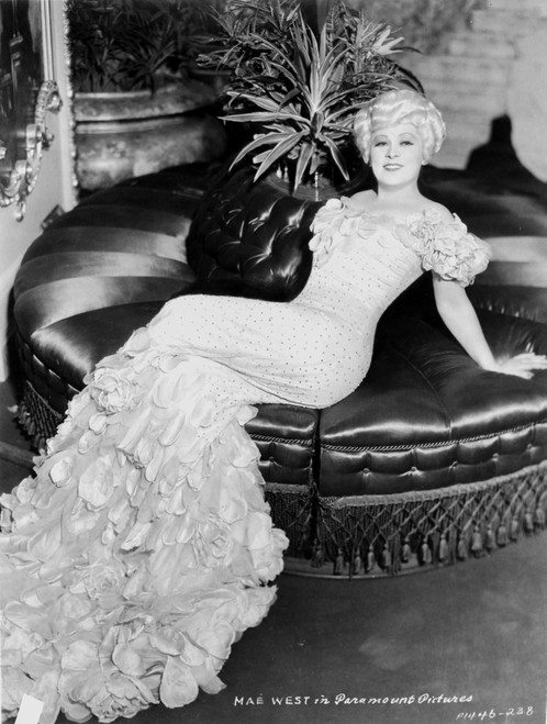 Mae West sitting on Couch, wearing White Gown with Floral Sleeves Photo Print - Item # VARCEL709672