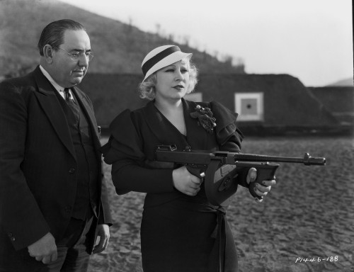 Mae West Holding a Gun with Man Behind Her Photo Print - Item # VARCEL709636