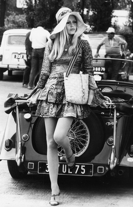 Brigitte Bardot wearing a straw hat by a car Photo Print (8 x 10)