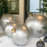 Medium and Large Silver Holiballs in snow lifestyle image with Silver and Gold toppers