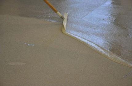 Concrete topcoat being applied to to finish concrete floor.