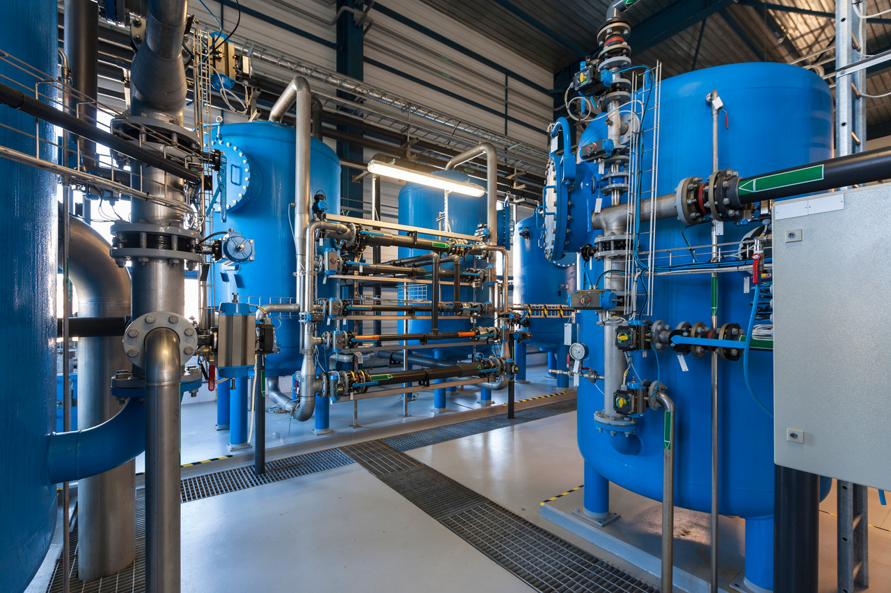 Industrial floor with equipment and pipes mounted to concrete floor.