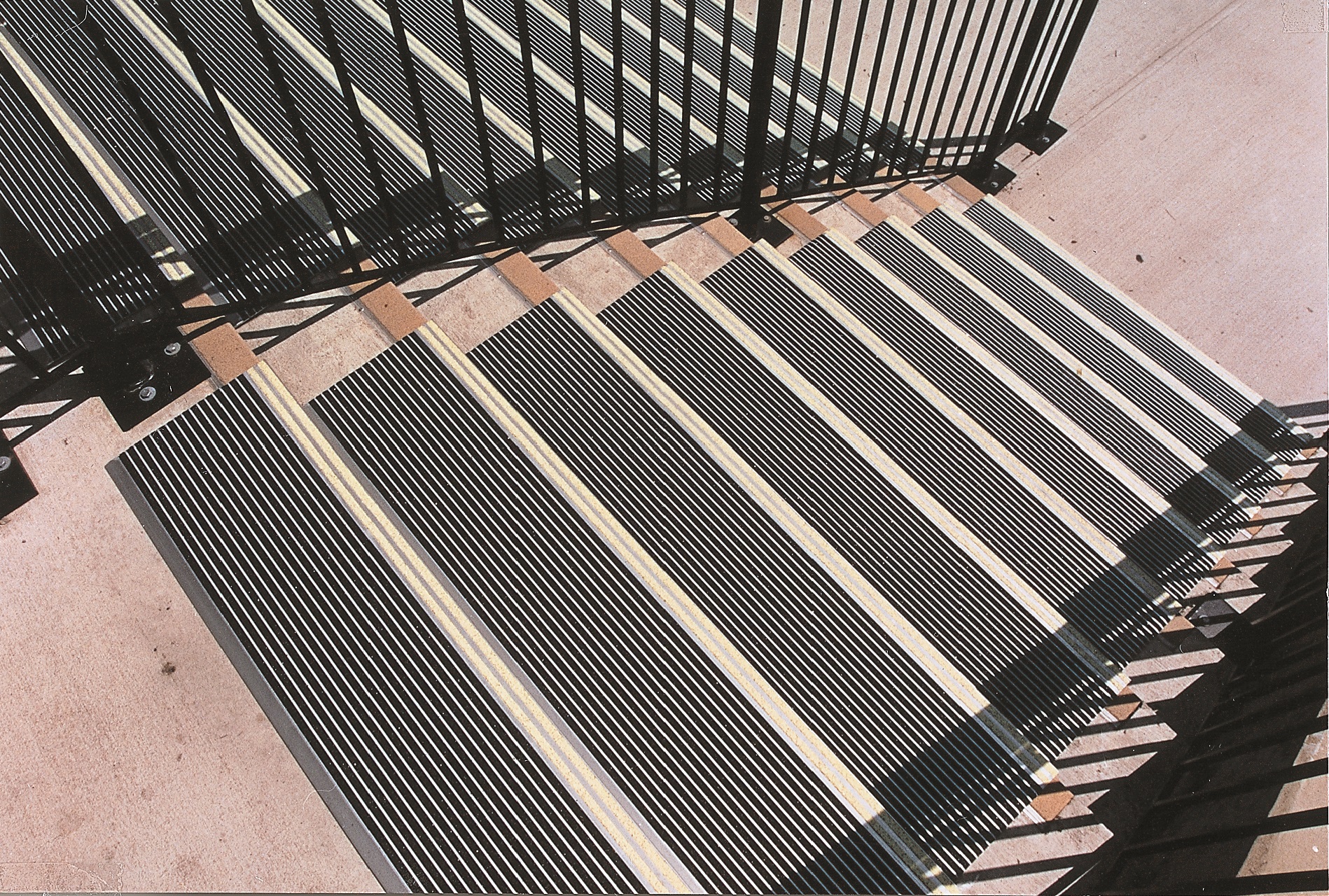 Concrete stairs with Garon Treds and metal rails mounted to the concrete.