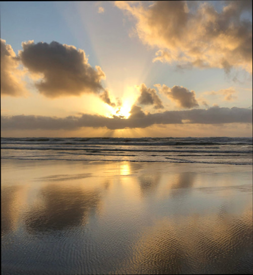 dramatic ocean sunset with clouds, sunrays, golds and blues