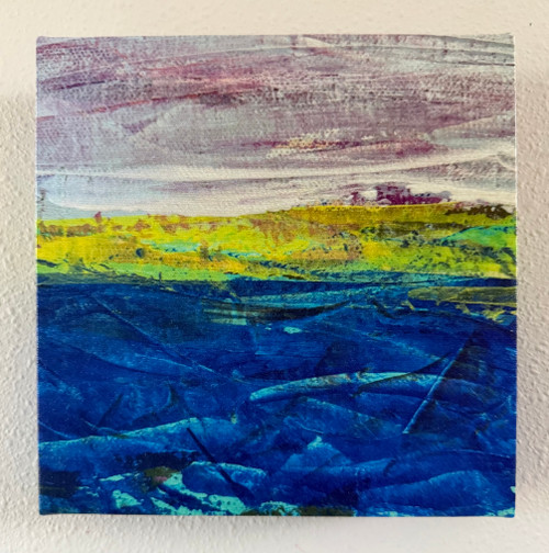 Photo of canvas print of original abstract landscape painting on canvas with deep blue ocean with turquoise line waves and purple and muted white sky, with yellow-green abstract land between them.