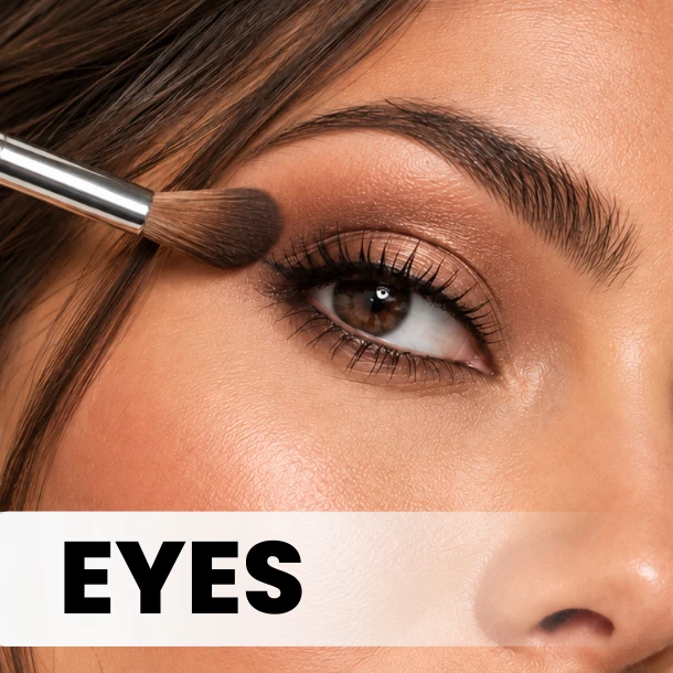 A woman with striking blue eyes carefully applies mascara to enhance her lashes and create a captivating look.