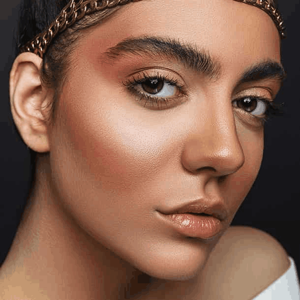 Stylish woman with a gold headband and makeup, showcasing a glamorous look.