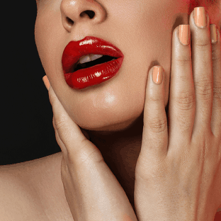 Stylish woman showcasing red lipstick and red nail polish, creating a bold and glamorous look.