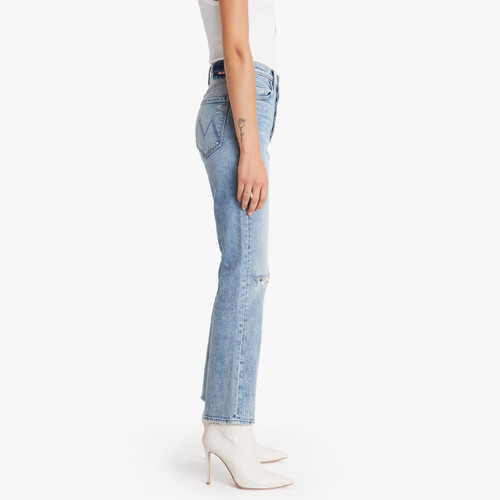 A picture of the side of the The Tripper High Rise Bootcut women's jeans from Mother that feature a light wash and distressed details.